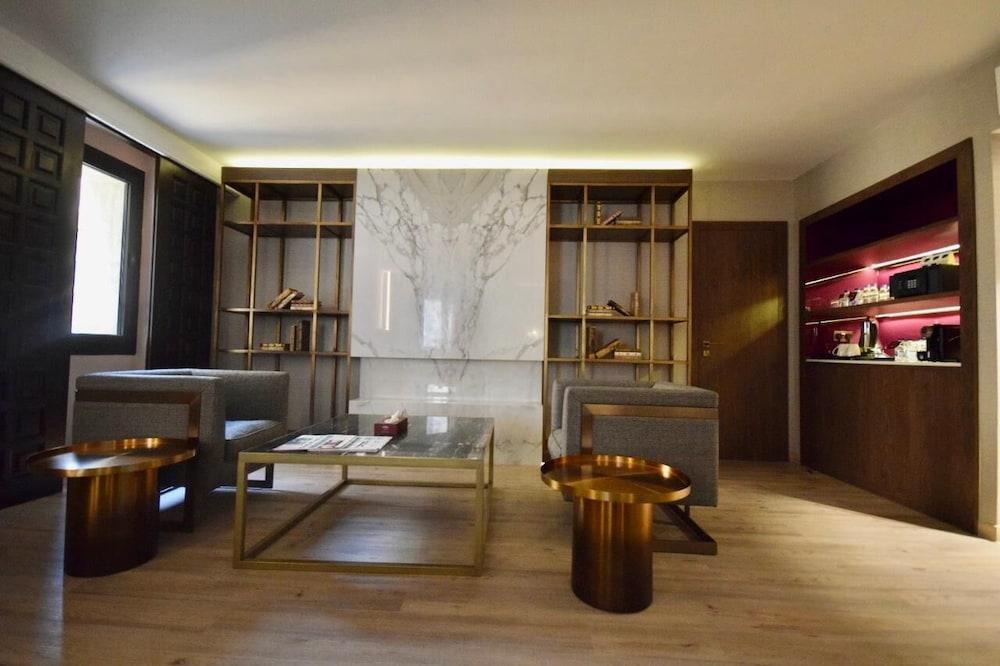 Makarem Ajyad Makkah Hotel La Meca Exterior foto The photo shows a modern and stylish interior space, likely a living room or lounge area. On the left side, there are two comfortable gray armchairs positioned toward the center. A glass coffee table sits between them, featuring a few magazines or bo