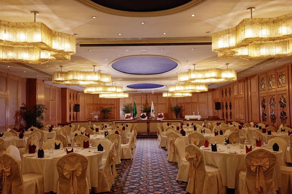 Makarem Ajyad Makkah Hotel La Meca Facilidades foto The photo shows an elegantly arranged banquet or conference room. There are several round tables covered with light-colored tablecloths and adorned with decorative napkins. The seating is also stylish, with chairs featuring matching coverings. The ro