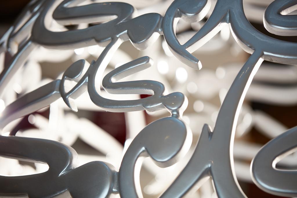 Makarem Ajyad Makkah Hotel La Meca Exterior foto The photo shows a close-up of a white, artistic structure or piece of decor that features intricate, stylized lettering. The letters are intertwined and have a fluid, modern design. The focus on the details reveals the elegance of the curves and shap