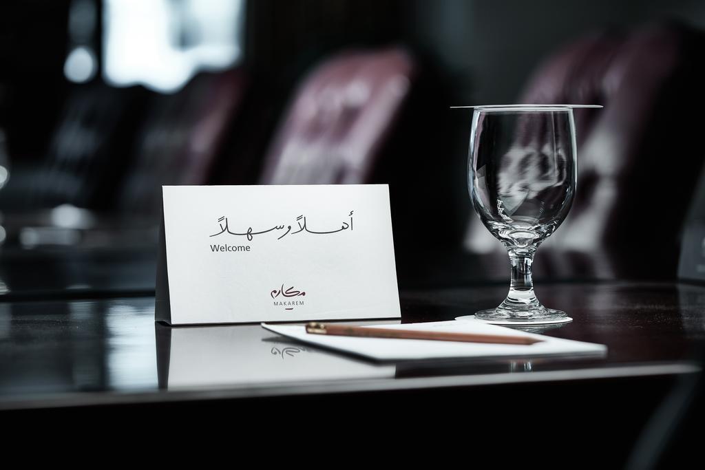 Makarem Ajyad Makkah Hotel La Meca Exterior foto The photo depicts a well-arranged table setting. There is a card in both Arabic and English that says "Welcome," placed on the table. Next to the card, there is a clear glass and a pen resting on a piece of paper. The background features leather seat
